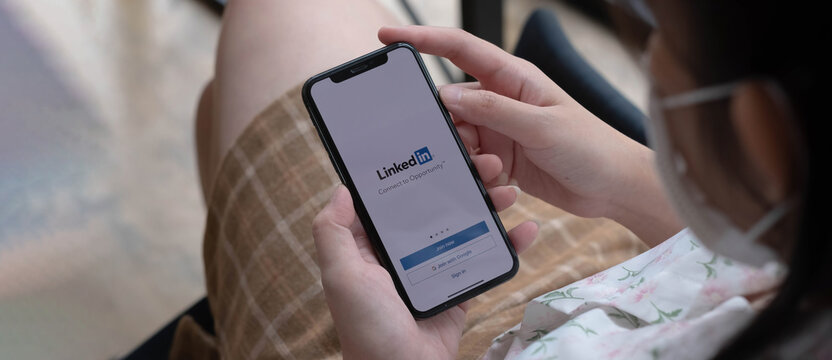 CHIANG MAI, THAILAND, NOV  14  2021 : A women holds Apple iPhone Xs with LinkedIn application on the screen.LinkedIn is a photo-sharing app for smartphones.