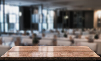 Empty wooden table top with lights bokeh on blur restaurant background.