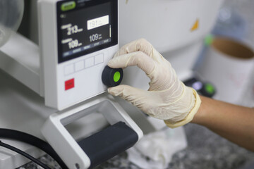 Closeup of a hand of woman scientist operating a rotary evaporator to make an experiment