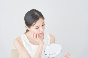 美容　鏡を見る女性　悩む