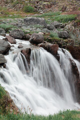 Fototapeta premium A full-flowing waterfall in the Murmansk region. The beauty of the northern nature beyond the Arctic Circle.