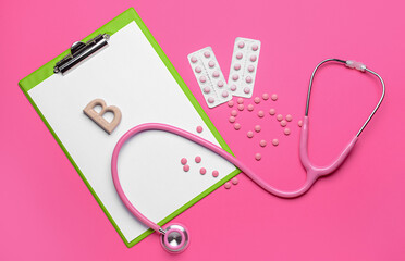Letter B with stethoscope, clipboard and pills on color background