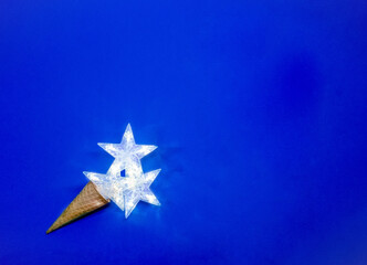 Decorative star lights on deep blue background. Christmas and New Year holiday decorations.