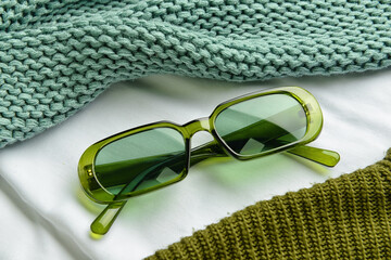 Stylish glasses on color fabric background
