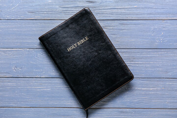 Black Holy Bible on blue wooden background