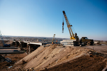 Fototapeta premium crane on the construction of the bridge on a warm spring morning