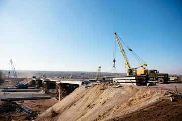 Fototapeta na wymiar crane on the construction of the bridge on a warm spring morning