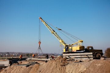 crane on the construction of the bridge on a warm spring morning