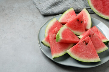 Delicious fresh watermelon slices on grey table. Space for text