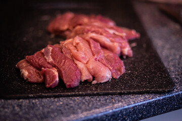a piece of meat, pork meat on a cutting board, raw red meat, fresh meat on the kitchen table