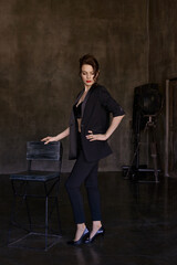 Stylish young girls in pantsuits pose in a photo studio.