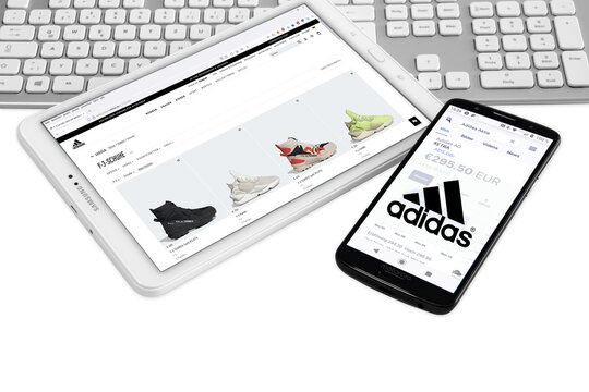 Addidas AG mit Logo Tablet Smartphone Tastatur Aktienmarkt wei&szlig;er Hintergund