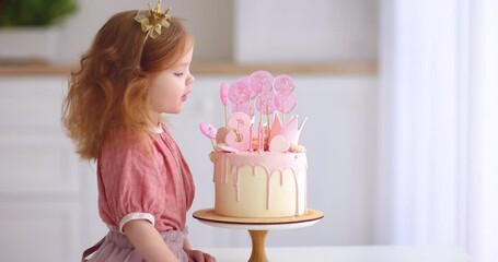 cute baby girl blowing the candlles on birthday cake. three years old