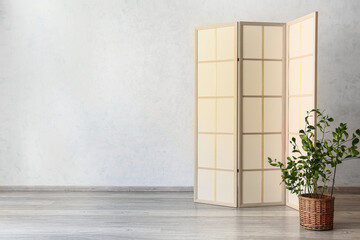 Stylish folding screen near wall in room interior