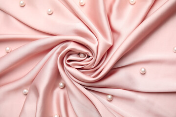 Many beautiful pearls on delicate pink silk, flat lay