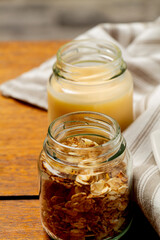 Granola cereal in a small glass jar and orange juice