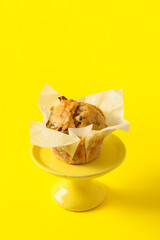Stand with tasty spinach muffin on color background