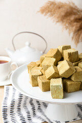 Stand with tasty hojicha marshmallows on table, closeup