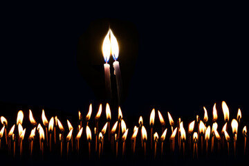Two thin candles stretch their lights towards each other. Their fire merges into one flame. The...