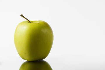 Green and yellow apple on a white background in a mirror image