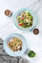 bulgur with vegetables and salad with fresh vegetables and meat on light background top view. dinner table top view with ingredients on table.
