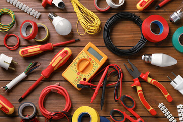 Flat lay composition with electrician's tools and accessories on wooden background