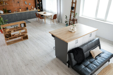 Obraz na płótnie Canvas Studio apartment with stylish sofa and contemporary kitchen