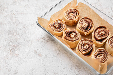 Baking dish of uncooked cinnamon rolls on white background, closeup