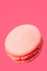 Pink pastel macaroons are flying on a pink background