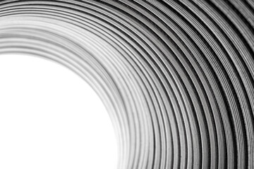 Flexible corrugated aluminum tube seen from the inside, resistant to high temperatures, isolated on a white background, selective focus. - obrazy, fototapety, plakaty