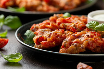 Greek tomato fritters, tomatokeftedes served with yogurt on plate.