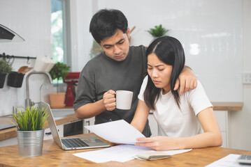 Stressed Asian couple reading notice mail from the bank about unpaid house mortgage