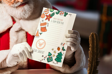 Santa Claus with letter at home on Christmas eve