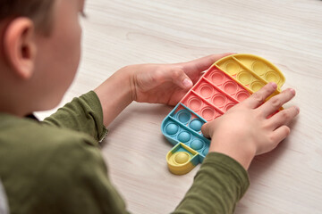 Kids hands push sensory pop it. Colorfull antistress toys, simple dimple, pop tube. Rainbow silicone sensory fidget New popular trendy silicone toy.