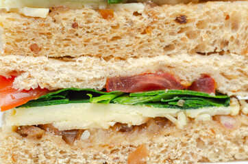 Closeup on a vegetarian sandwich with cheddar cheese, tomato, spinach with mango and apricot chutney in seeded malted bread