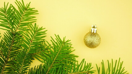 New Year  composition of decorations on  yellow background. Christmas background with Christmas balls and fir branches. Top view, copy space, flat lay.	