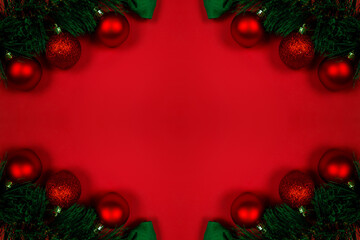 Fototapeta na wymiar Christmas composition with decorations, fir tree branches on red background. Flat lay, top view, copy space. Minimalistic stylish background for design free space.