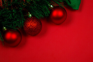 Christmas composition with decorations, fir tree branches on red background. Flat lay, top view, copy space. Minimalistic stylish background for design free space.