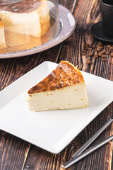 Sliced san sebastian cheesecake with coffee on wooden table
