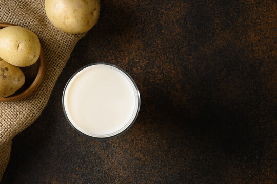 Vegan Potato Milk And Potato On Brown Background. Plant Based Milk Replacer And Lactose Free. View From Above.