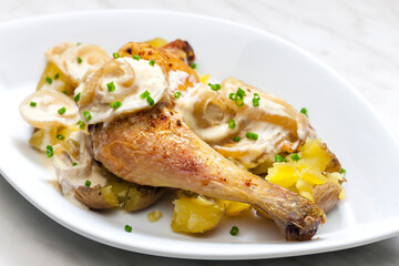 chicken leg on creamy onion sauce with potatoes