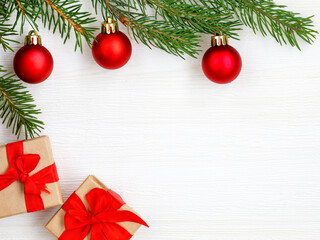 Christmas frame. Gift box, fir tree branches, red balls on white background. Christmas, winter, new year minimal concept. Flat lay, top view, copy space