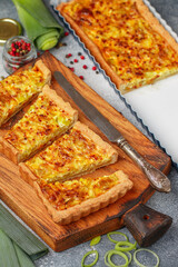 Freshly baked homemade onion pie stuffed with leeks, eggs and cheese on a wooden board. Tart. quiche. Homemade pastries for gourmets. Breakfast. Brunch. Selective focus