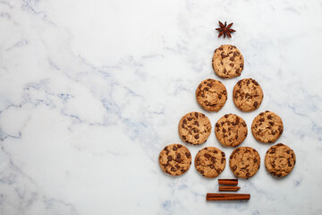 Freshly baked homemade cookies with dark chocolate on a marble background. A festive treat. The concept of home baking. Selective focus, top view and copy space