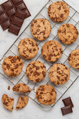 Freshly baked homemade cookies with dark chocolate on a marble background. A festive treat. The concept of home baking. Selective focus, top view