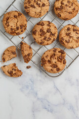 Freshly baked homemade cookies with dark chocolate on a marble background. A festive treat. The concept of home baking. Selective focus, top view and copy space