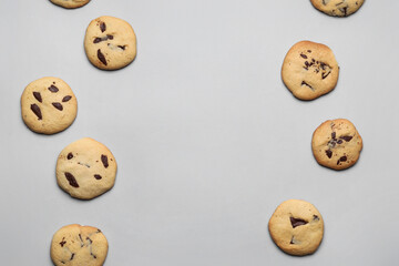 Delicious homemade cookies with chocolate chips on grey background