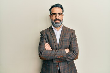 Middle age man with beard and grey hair wearing business jacket and glasses happy face smiling with...