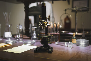 Vintage old microscope on table for science background. Medicine, alchemy, pharmacist. glass jars,...