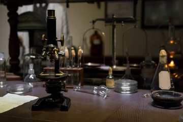 Vintage old microscope on table for science background. Medicine, alchemy, pharmacist. glass jars,...